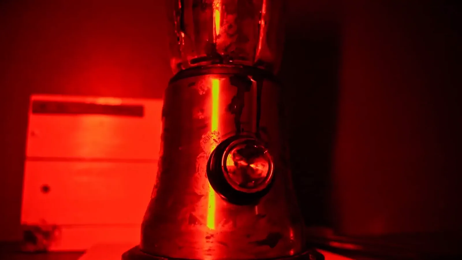 A steel blender lit blood red in the Cannibal kitchen