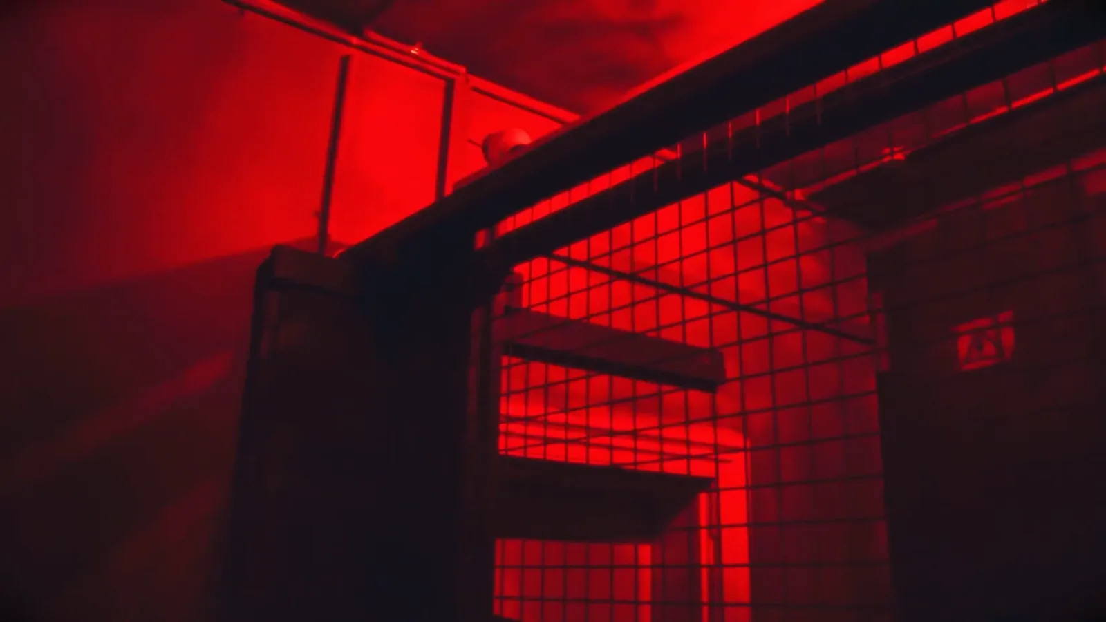 A wire cage glowing red inside the Cannibal meat locker